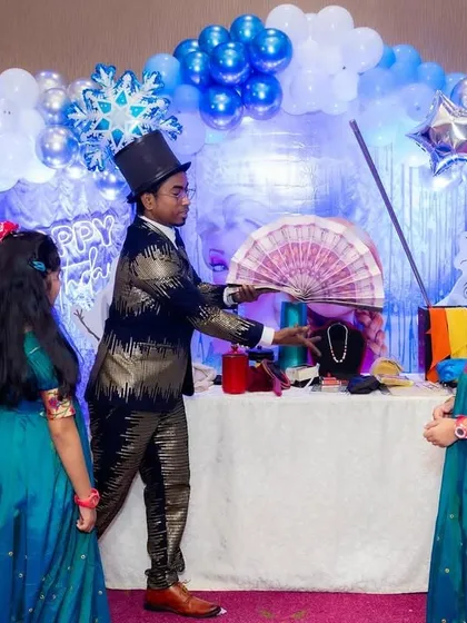 Another moment from a stage show, where I use classic props like a fan to create a colorful and surprising magic trick for my young assistants.