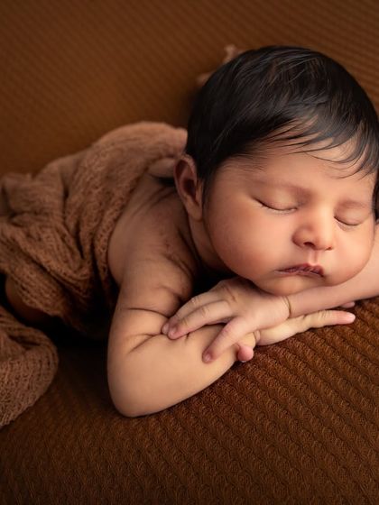 This is a classic newborn pose, often called the "taco pose," where the baby is gently curled up. It showcases their tiny hands and feet while keeping them snug and secure.