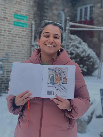 Here I am, all bundled up, proudly holding my sketchbook with the finished painting of a snowy backyard. Sketching in the cold is a unique experience!