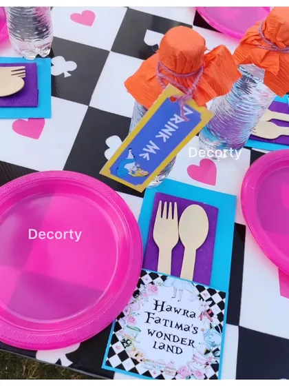 The kids' table setting, complete with themed plates, "Drink Me" tags on bottles, and custom place cards.