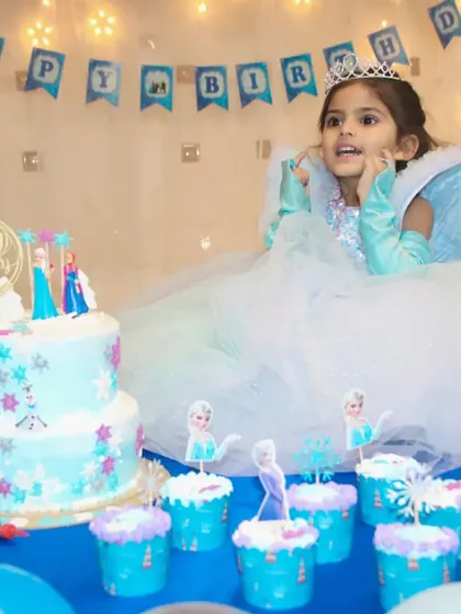 The birthday girl looking at her amazing two-tier Frozen cake. Capturing the child's wonder is a key part of my photography.