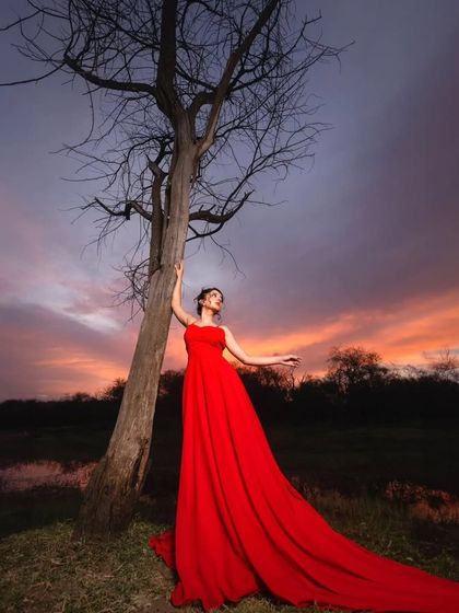 The beauty of a dramatic gown against a dramatic sky. This red trail gown is the perfect outfit for creating breathtaking pre-wedding photos.