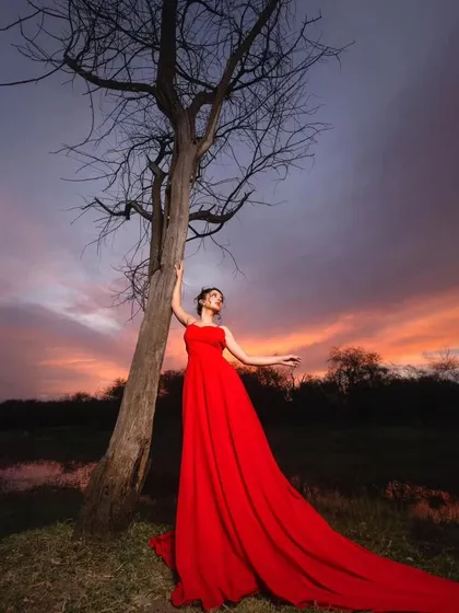 The beauty of a dramatic gown against a dramatic sky. This red trail gown is the perfect outfit for creating breathtaking pre-wedding photos.