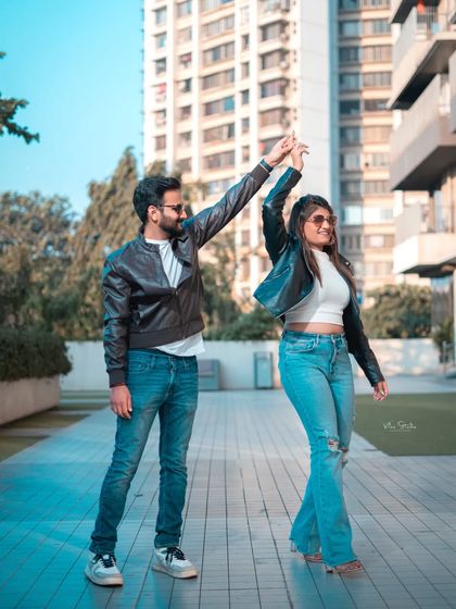 A fun and dynamic shot in a modern urban setting. The couple is dancing, full of energy and laughter, showing that a city shoot can be playful and candid.