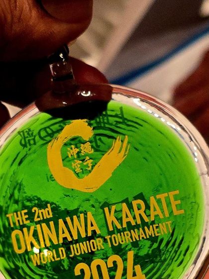 The unique green glass medal awarded at the 2nd Okinawa Karate World Junior Tournament. These awards are not just medals but beautiful pieces of Okinawan craftsmanship.