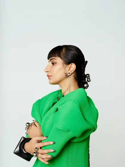A side profile capturing the silhouette of the dress and the intricate, accessorized hairstyle.