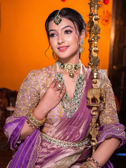 For this South Indian bridal look, we paired a modern lilac saree with traditional emerald jewelry. I focused on creating dewy, luminous skin and soft, defined eyes to achieve a look that felt both royal and effortlessly graceful.