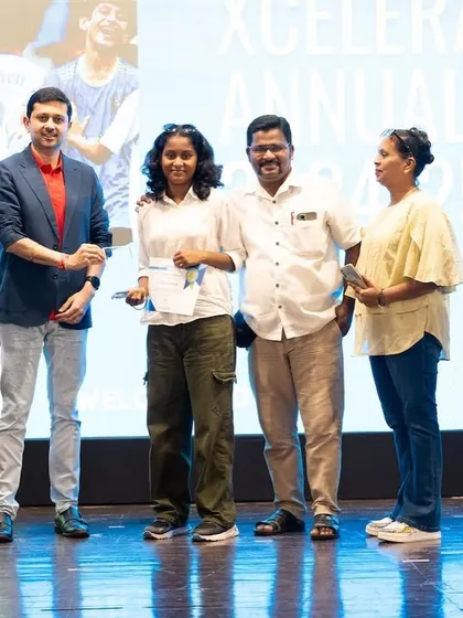An award winner from our girls' program with her proud family at the Xcelerate Annual Day.