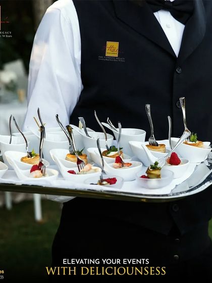 Elevating your events with deliciousness. A professionally dressed server holds a tray of assorted single-bite appetizers, showcasing the elegant and convenient canapés we offer for cocktail hours and receptions.