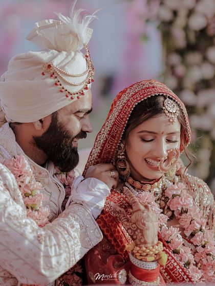 The groom gently adjusts a flower on his bride, a small, intimate gesture of love captured during their wedding.