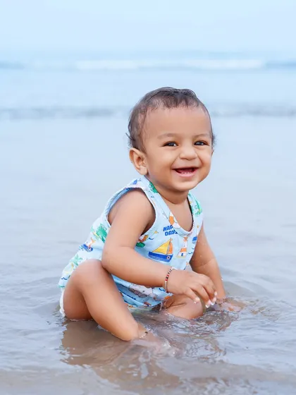 There's nothing like a baby's first experience with the ocean. This little one's happy smile while splashing in the water is a priceless memory from our beach photoshoot.