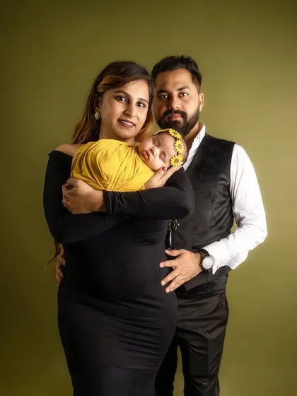 A tender moment captured as the new mother holds her baby close, with the father's protective arm around them both. This pose emphasizes the new family unit.