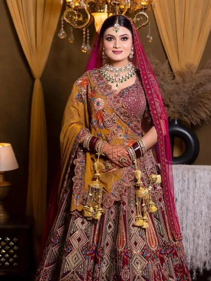 A bride in a magnificent multi-colored lehenga, perfectly complemented by our elegant green Kundan jewellery set and traditional kaleere.