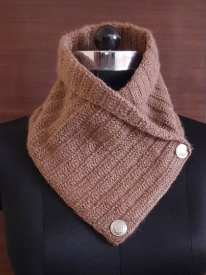 This crochet neck warmer in a warm, earthy brown is a versatile accessory for any winter wardrobe. The button-up design makes it easy to wear and adds a touch of rustic charm.