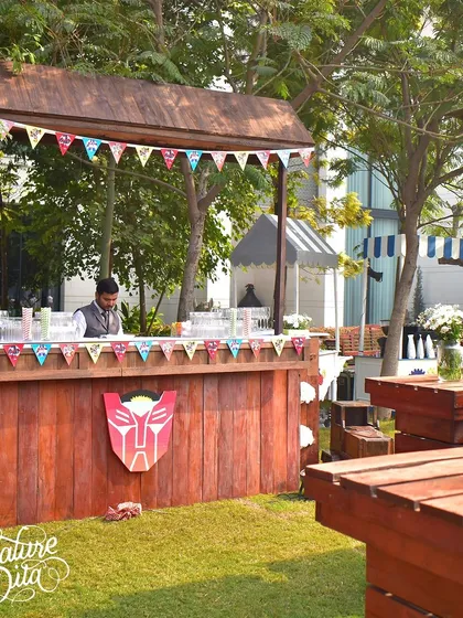 A rustic wooden bar decorated with a Transformers logo for the kids' party.