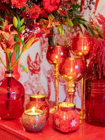 A close-up of the table decor from the 'Red Room' Sangeet. Red glassware, candles, and floral arrangements came together to create a rich and luxurious tablescape.