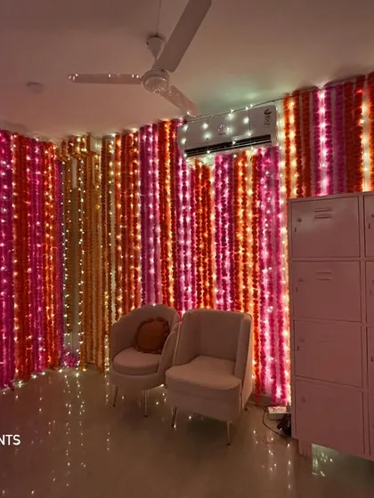 The same marigold wall setup, showing how it transforms the corner of a room into the main event space. The lighting creates a warm and inviting ambiance.