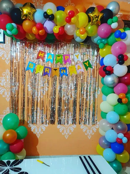 A classic and colorful birthday decoration. This balloon arch with a shimmer curtain and a "Happy Birthday" banner is a simple and festive choice for any age.