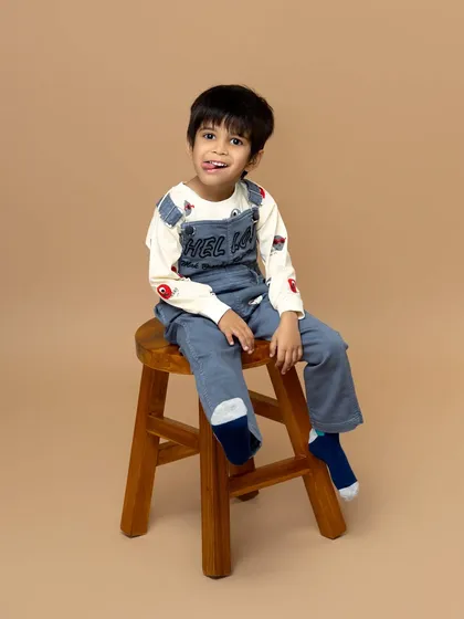 A playful and candid moment captured in the studio. This little boy's cheeky expression shows off his fun personality in this simple and clean portrait.
