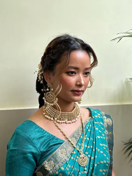 A side view of this South Indian bridal look, showcasing the beautiful braided hairstyle and traditional hair accessories that complete the look.