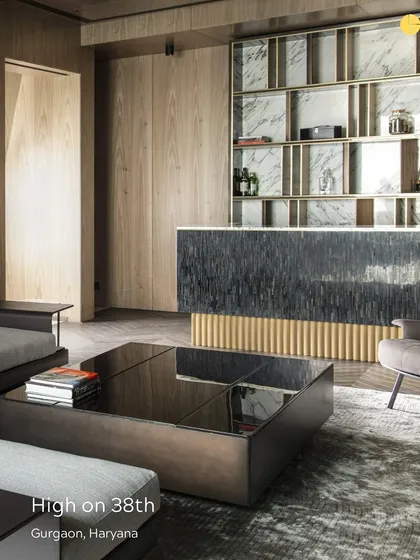 A detail from the 'High on 38th' penthouse in Gurgaon. This entertainment area features a striking bar with a textured stone front and brass accents, blending sophisticated materials with a bold design statement for a luxurious feel.