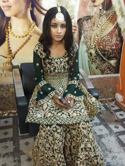 A striking look for a Mehndi or Sangeet function. The makeup is bold to match the dark green sharara suit.