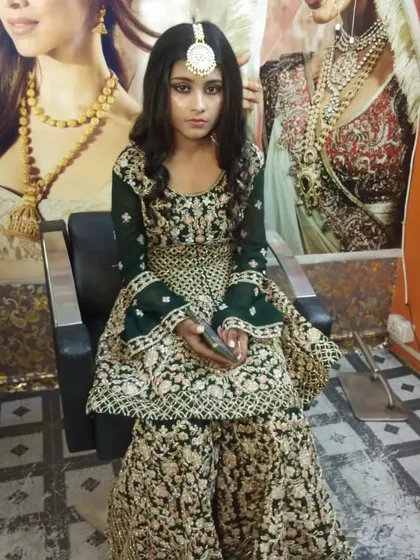 A striking look for a Mehndi or Sangeet function. The makeup is bold to match the dark green sharara suit.