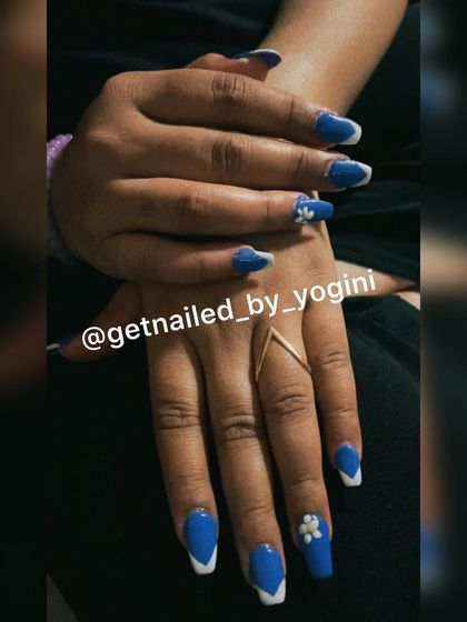 A beautiful set of acrylic extensions with a blue and white V-shaped French tip design. I also added a 3D white flower for an extra touch of elegance.
