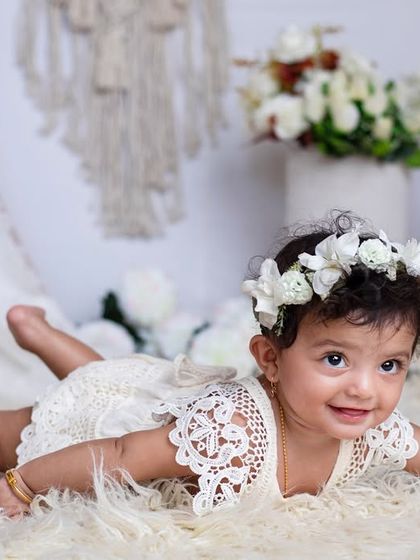 Such a cutie! This simple, elegant setup with a floral crown and a soft white rug lets this baby girl's natural charm shine through.