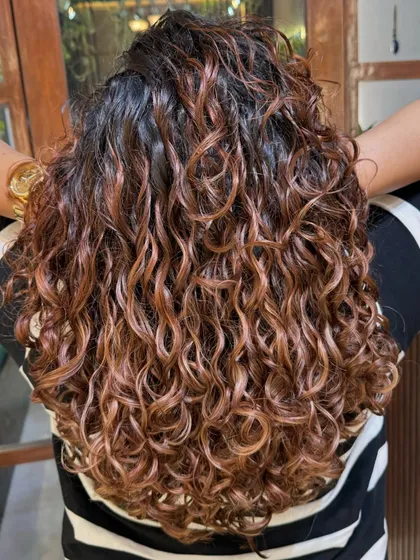 Life's too short for boring hair! These golden-brown highlights were created with Wella professional colors to give a beautiful, sun-kissed glow to her curls.