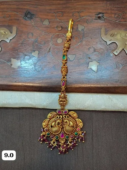 A delicate and lightweight maang tikka with a double peacock motif. Made from 92.5 silver with gold plating, it's perfect for those who prefer a more subtle hair accessory.
