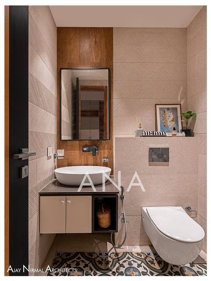 This guest washroom in Apartment 704 uses a combination of a highlighter tile, a base tile, and patterned floor tiles. The design is compact but visually rich, with wooden elements adding warmth.