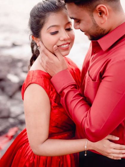 A tender moment between the couple. The focus here is on the connection, with the vibrant red of the gown providing a beautiful, warm frame.