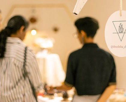 A visitor checking out the intricate details of a student's work. The quality of the pieces at GLAZED is always top-notch.