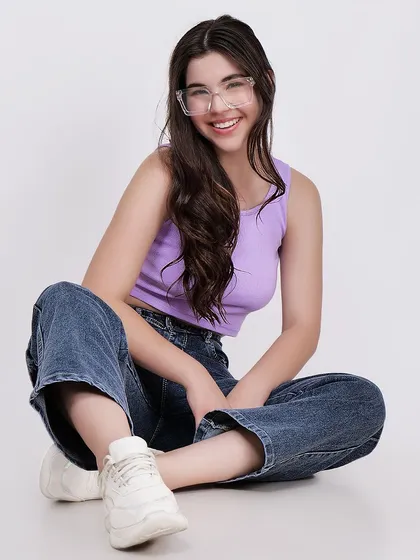 A happy and relaxed pose from a model wearing a lavender tank top and wide-leg jeans, perfect for lifestyle branding.