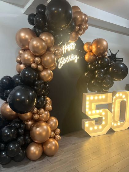 Another angle of the sophisticated black and bronze 50th birthday decor. The arrangement is perfect for creating a dramatic photo corner at any adult party.