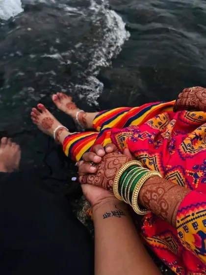 Another angle of the couple by the water, showing the lovely stain of the bride's hand and foot mehndi. It’s a beautiful way to capture the memories of your special day.