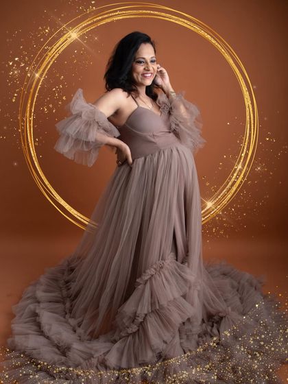 A joyful solo portrait with a golden halo effect. The beautiful smile and the elegant pose in this ruffled gown perfectly capture the happiness of pregnancy.