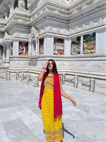 Standing in front of the magnificent Prem Mandir in Vrindavan, wearing a bright yellow suit. A beautiful travel and spiritual moment.