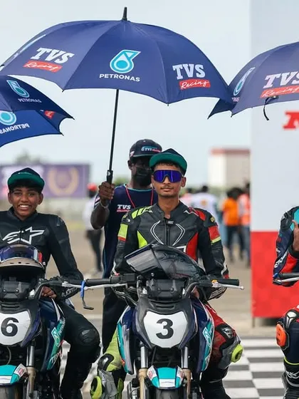 The future of Indian racing, lined up and ready to go. Our rookie riders sit on their TVS race bikes on the starting grid, supported by our team under the official umbrellas, showing the professional environment we create.