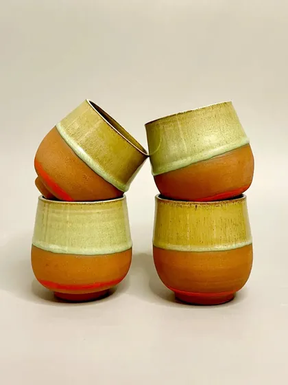 These tumblers, with their warm terracotta base and light green glaze, are designed to be versatile. They are perfect for water, juice, or even cocktails, adding character to any beverage.