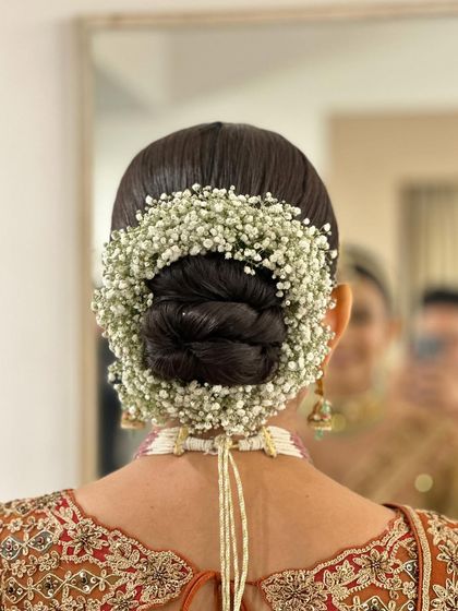 A close-up of the baby's breath gajra, showing the delicate texture of the flowers.