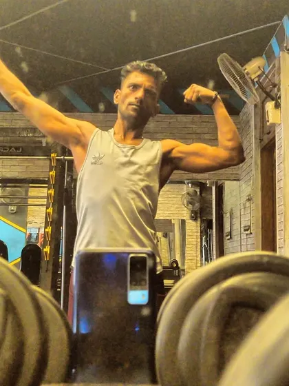 A mirror selfie showing a bicep flex. Capturing these moments helps track progress and celebrate small wins along the way.