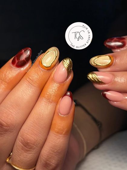 This set combines multiple techniques, including the tortoise shell pattern, a deep red French tip, and a unique 3D gold accent.