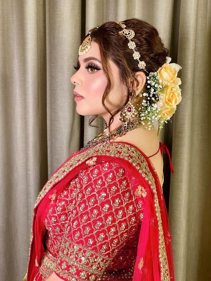 A side profile showcasing the elegant hairstyle with yellow roses and the beautifully blended makeup.