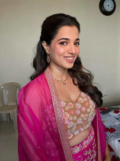A happy, smiling portrait of the bride. The soft pink tones on her cheeks and lips give her a fresh and youthful glow, perfect for her mehendi ceremony.