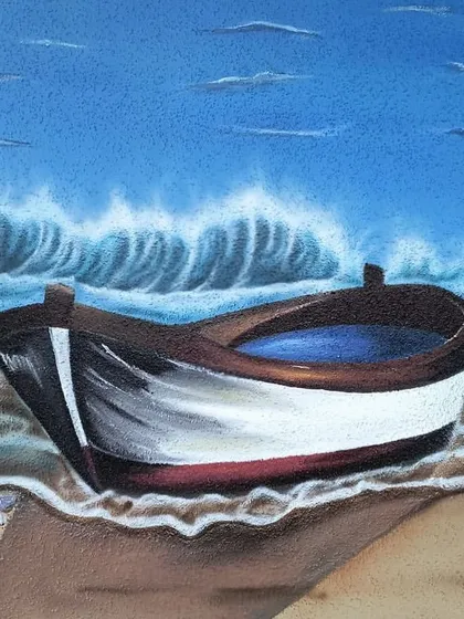 A close-up of the boat resting on the sand.
