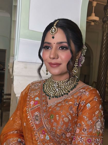 A full-face view of the bride, showcasing how a well-structured updo can enhance the overall look, balancing the heavy jewelry and ornate outfit.