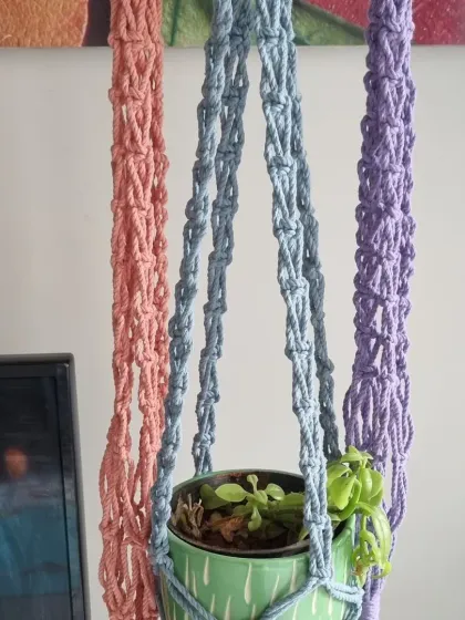 Give your plants a beautiful floating home. I create these macrame plant hangers in a variety of colors, like the soft pink, gentle blue, and lavender shown here. They are a simple way to add a touch of green and handmade warmth to any room.