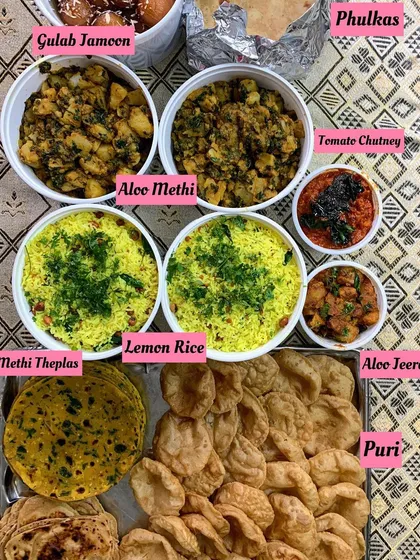 An everyday meal made special with love. This spread includes Aloo Methi, Lemon Rice, Methi Theplas, Puris, and Gulab Jamoon for a complete and satisfying feast.